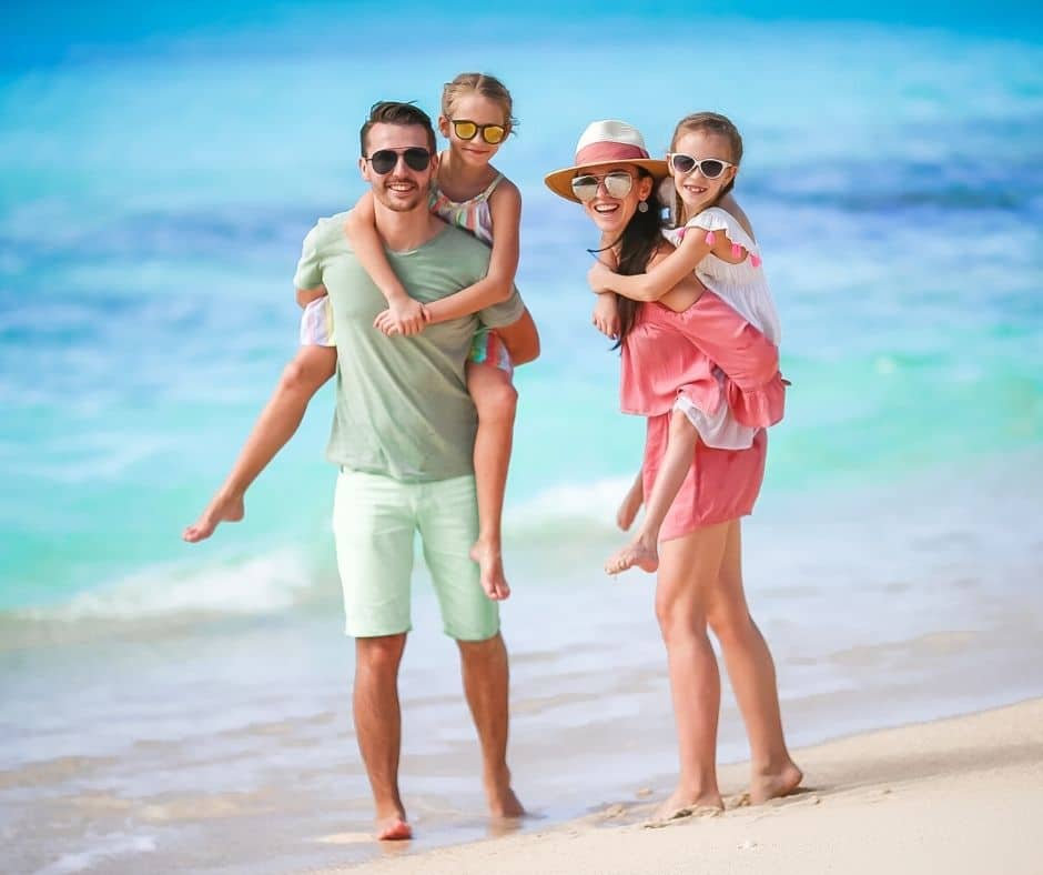 Family on the beach with sunhats and sunglasses