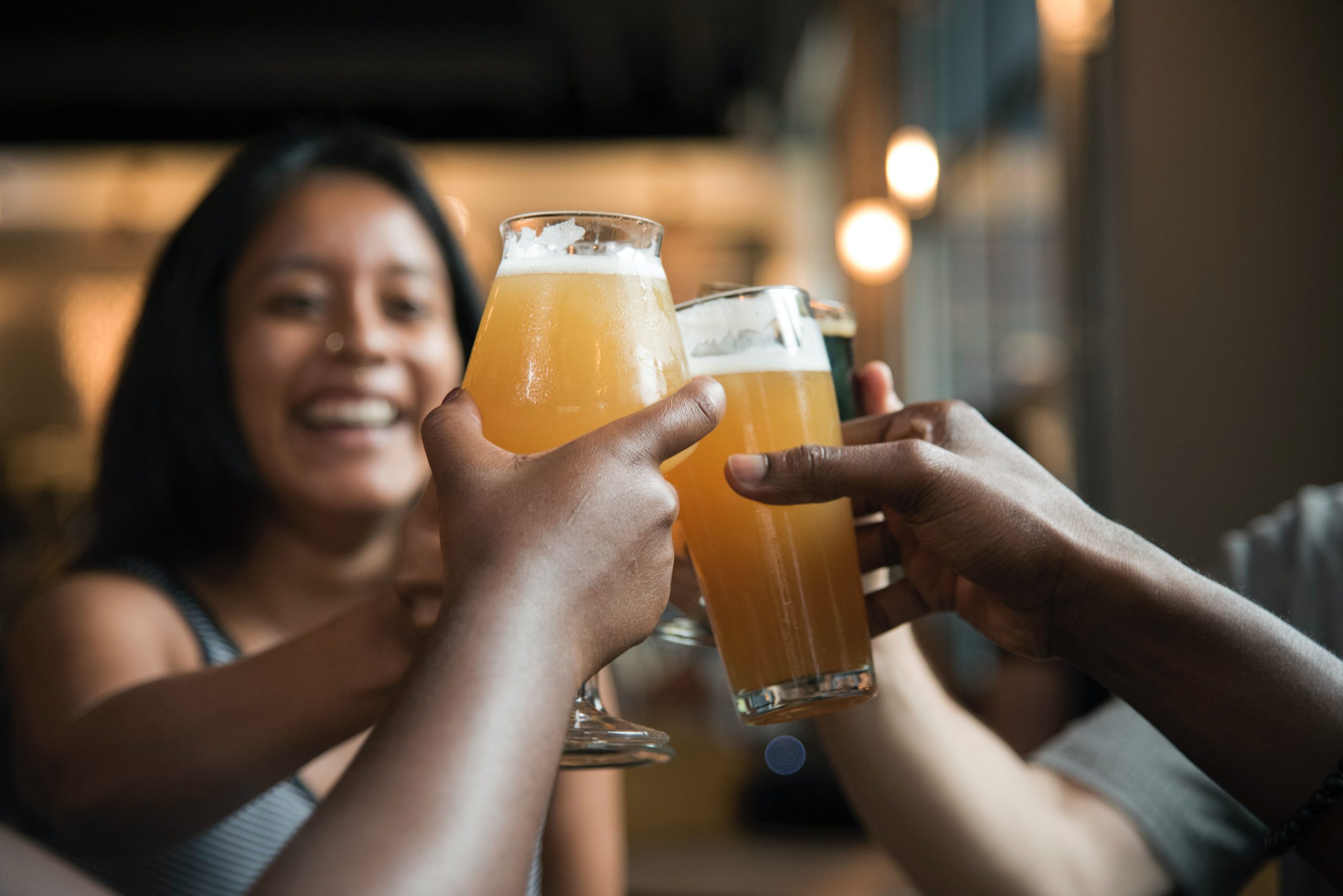 Close up of two beer glasses clinking together