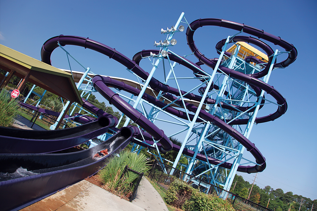 A large water slide complex with purple slides and a blue tower