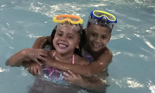 Siblings Hugging in the pool