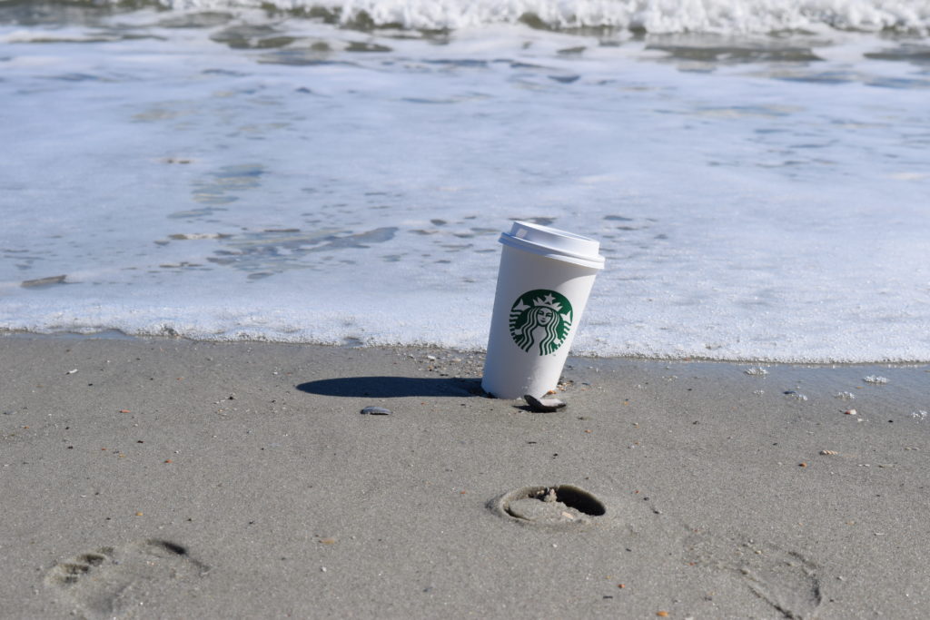 Starbucks cup in sand on the beach