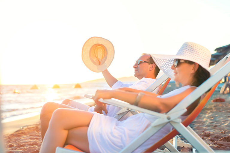 Couple relaxing on the beach at a Bay View Resort winter rental.