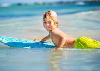 Boy-Surf-At-The-Beach-shutterstock_162352100-scaled-1.jpg
