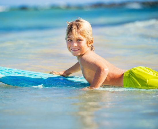 Boy-Surf-At-The-Beach-shutterstock_162352100-scaled-1.jpg