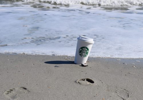 Starbucks cup in sand on the beach