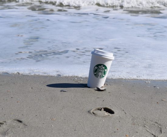 Starbucks cup in sand on the beach